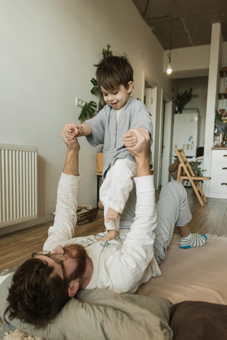 A joyful father and son playing together indoors, showcasing family bonding and happiness.