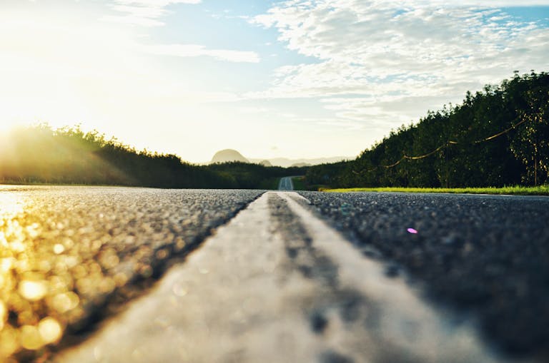 Serene road stretching through lush landscape during sunset in Kangar, Malaysia.